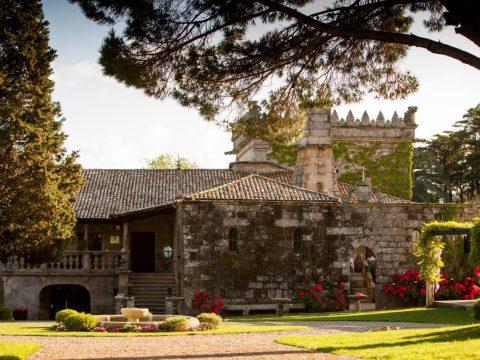 Pazo gallego de granito al atardecer, jardines con fuente y flores – visita a pazos en las Rías Baixas (Galicia)